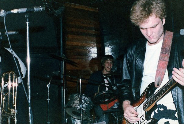 Color photo of guitarist and drummer