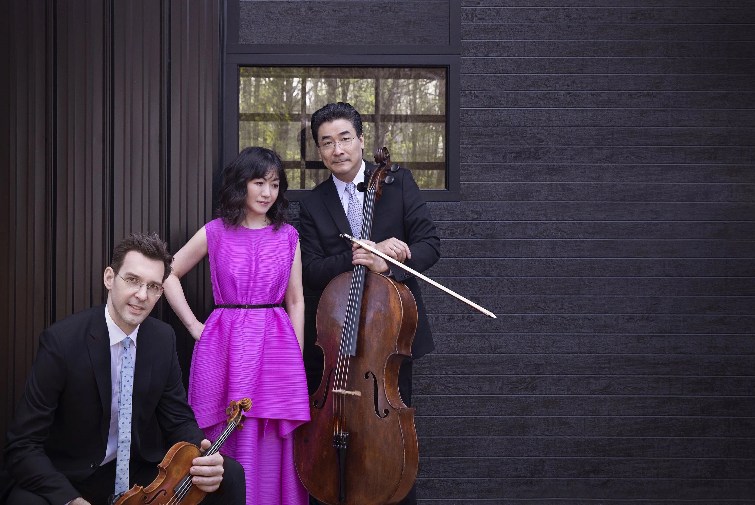 The The Horszowski Trio pictured in front of a dark exterior wall.; Recital and Masterclass: The Horszowski Trio