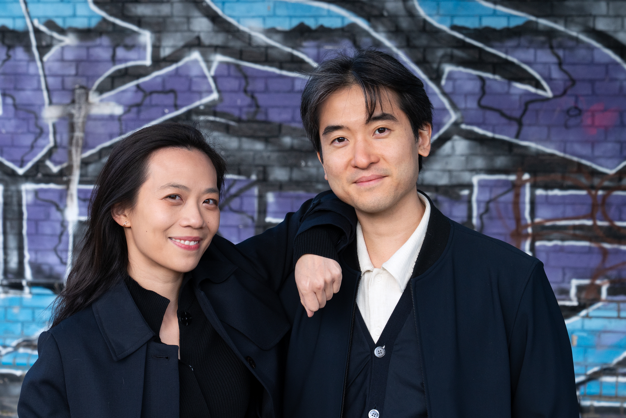 Christine Wu (left) and Tomoki Park (right) smiling against a brick wall covered in graffiti. ; Alumni/ae Spotlight: Tomoki Park APS '19, piano, with&nbsp;Christine Wu, piano