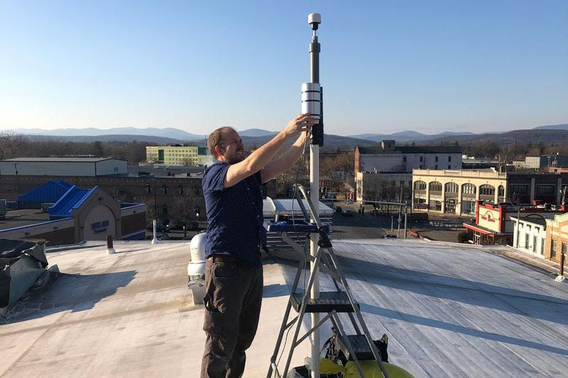 Dr. Eli Dueker installing a MetOne 212-2 particle profiler atop the Andy Murphy Neighborhood Center in Midtown Kingston. Courtesy City of Kingston