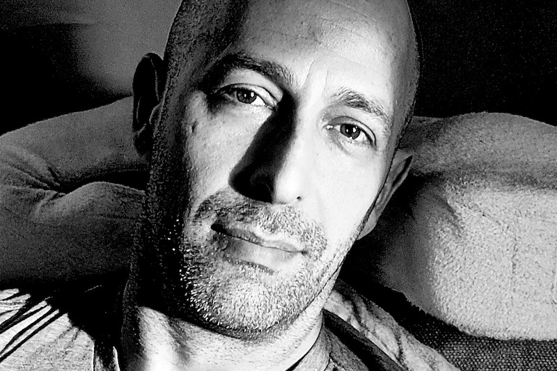 A black and white photo of Wyatt Mason smiling at the camera.