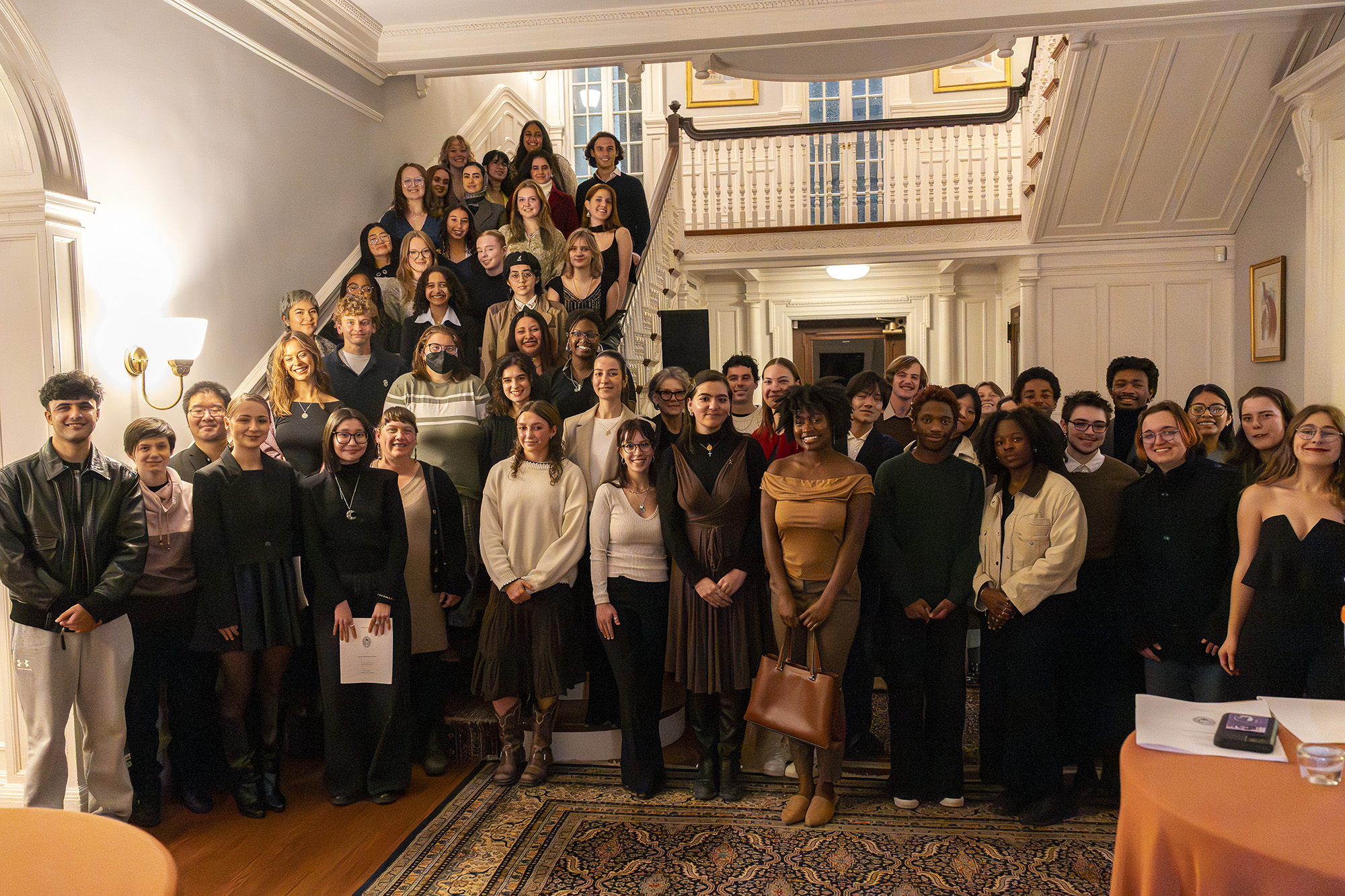 A group of students and donors stand together at an evening event