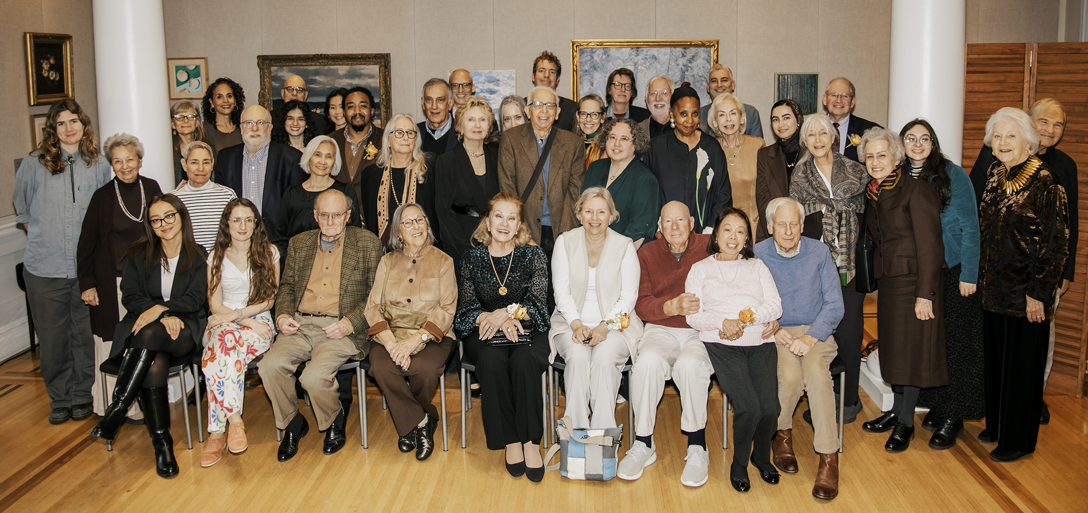 a group of donors and students gather together between two columns