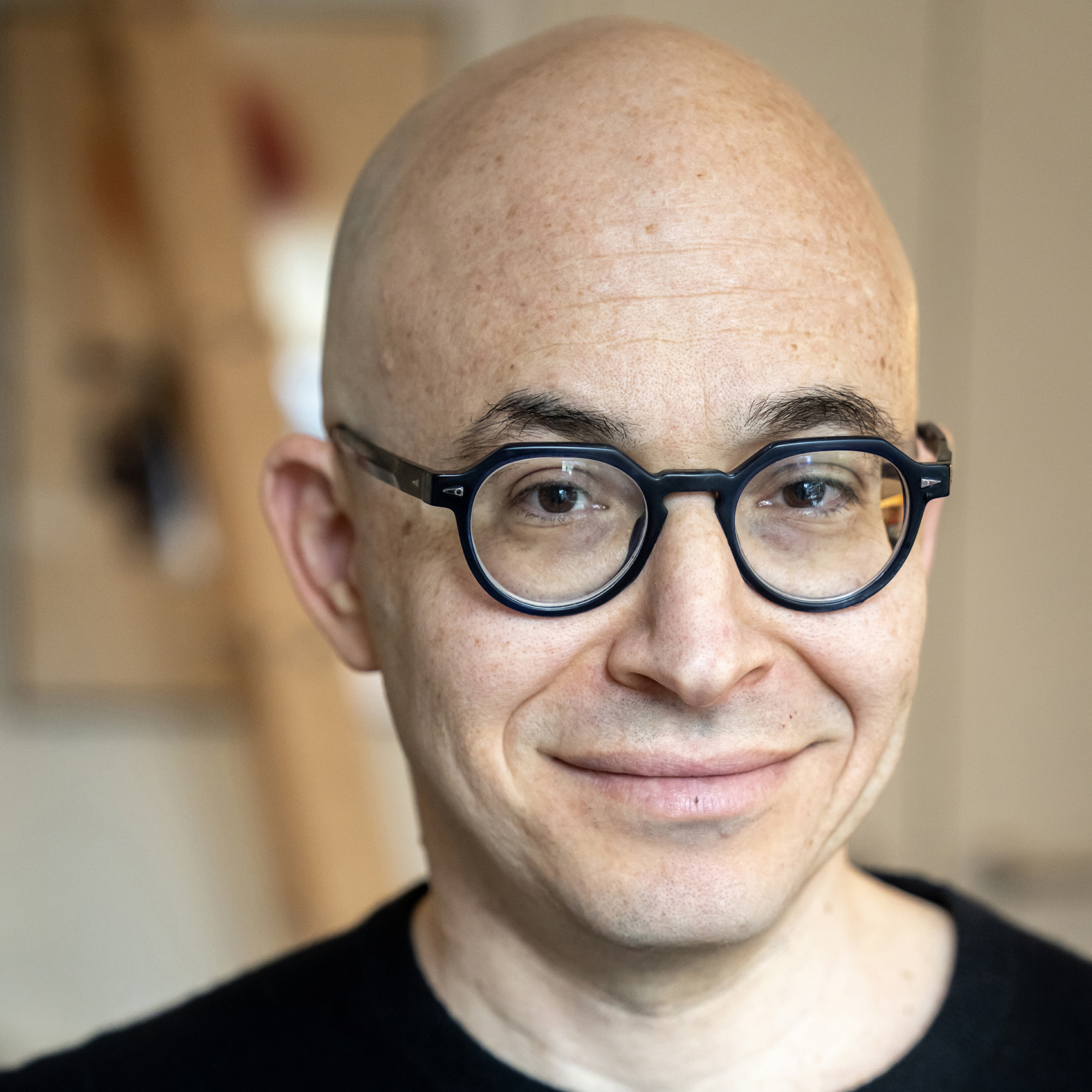 a man in glasses smiles at the viewer