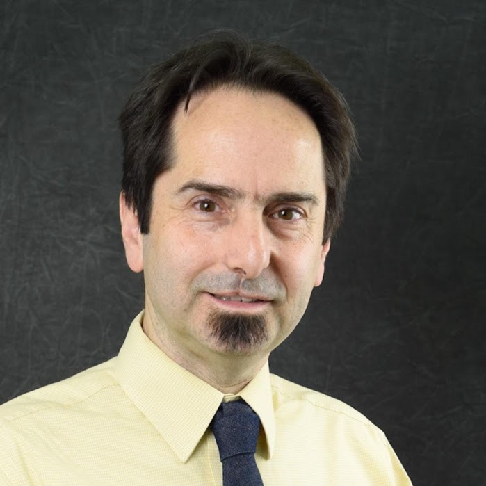 a portrait of a man in a yellow shirt and gray tie