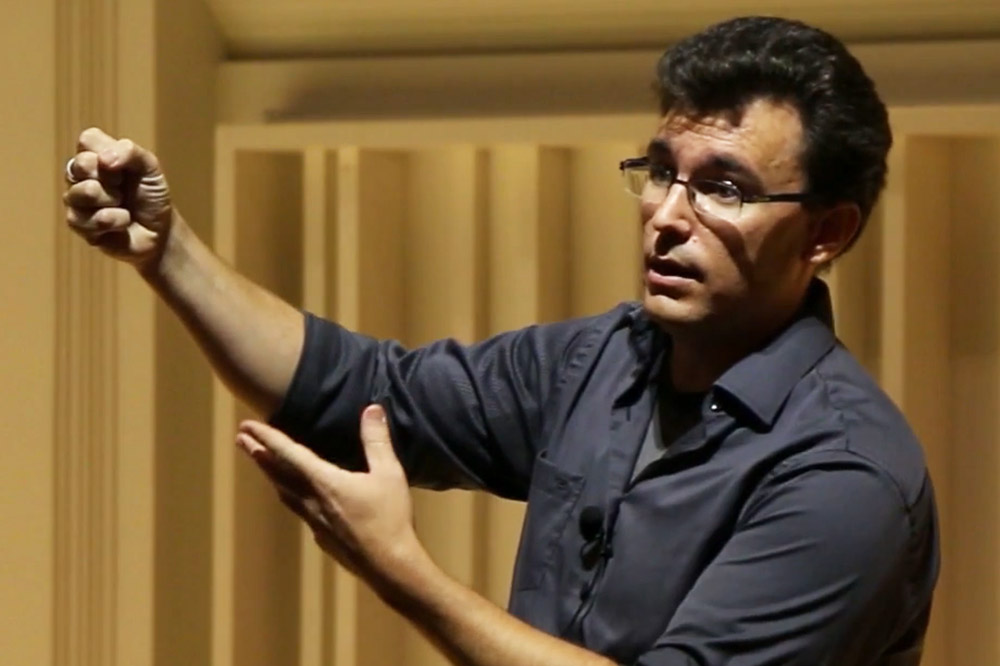 a man in a blue shirt gives a lecture demonstration