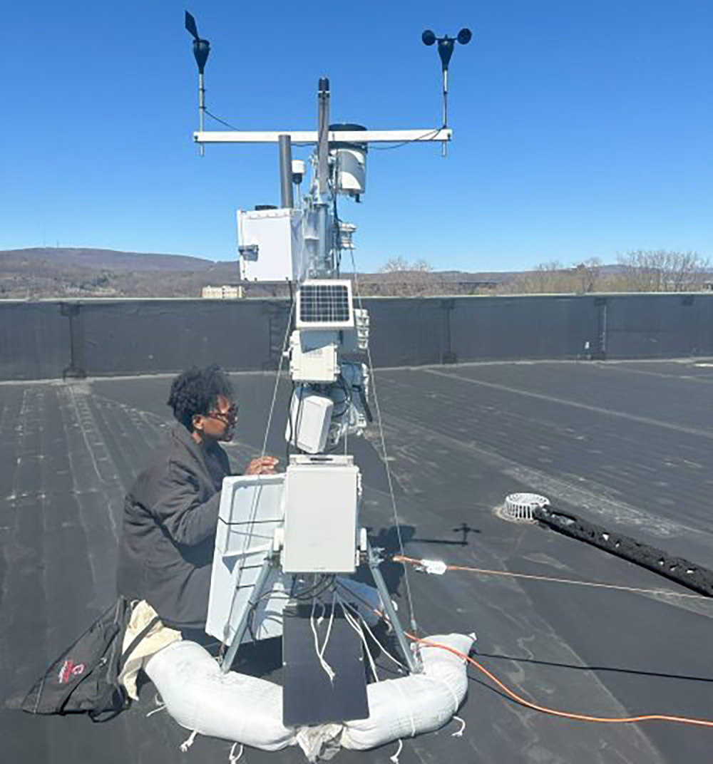 a woman installs a paneled device on top of a building