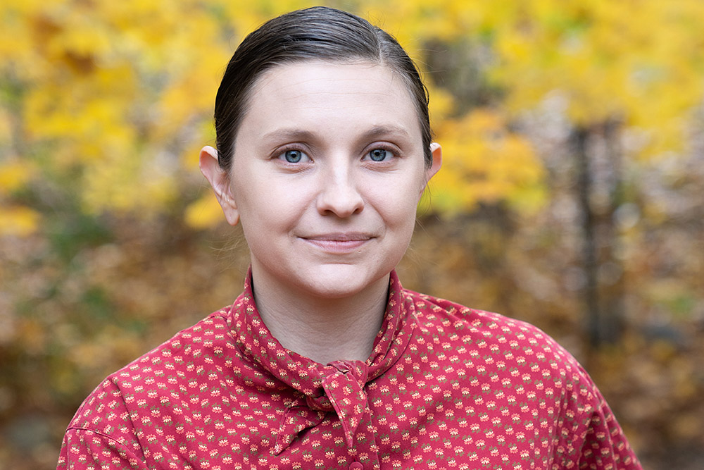 a woman with hair pulled back in a red polka dot shirt