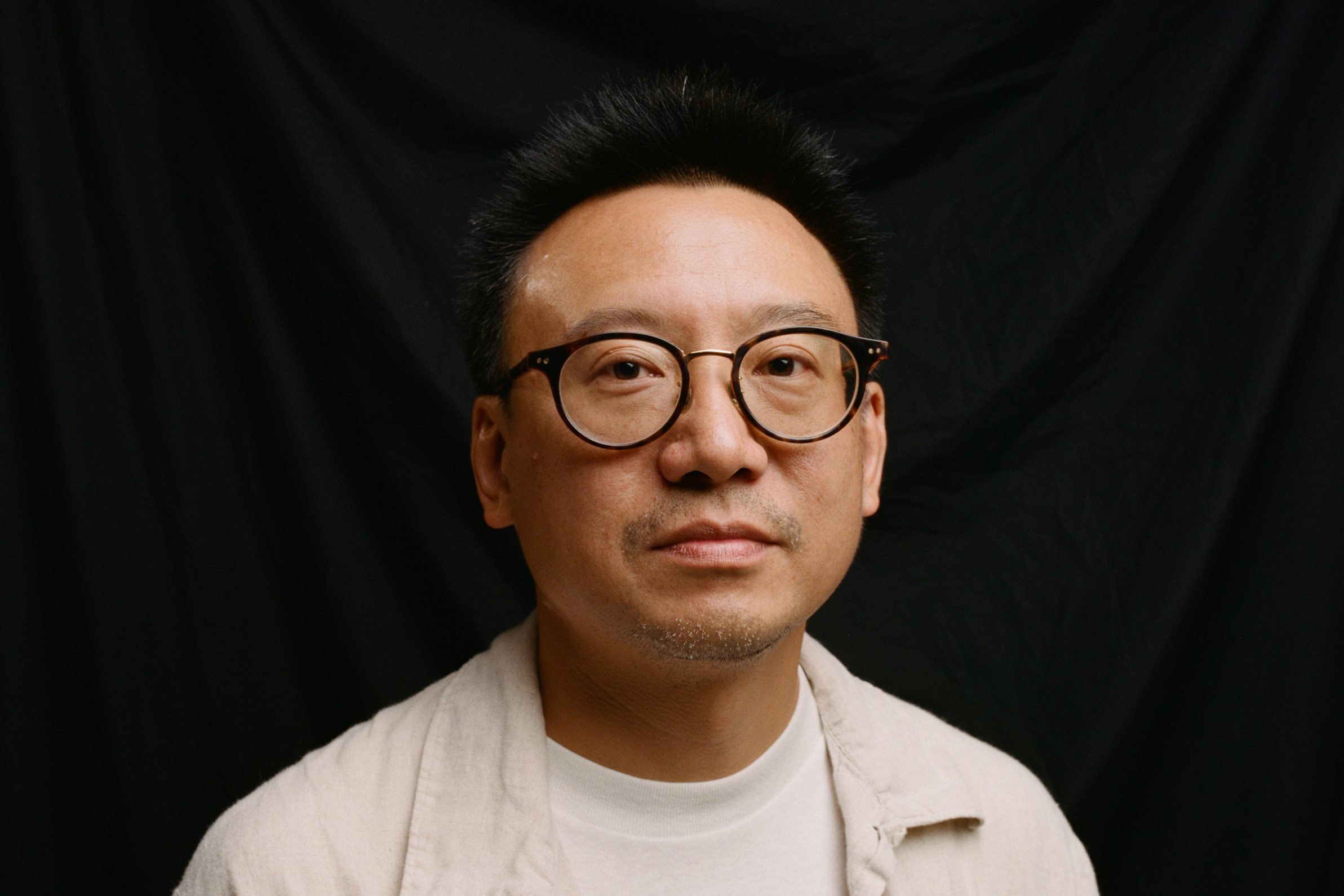A professional photograph of Hua Hsu in front of a black background.