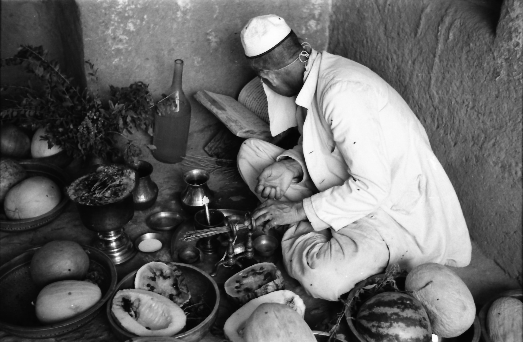 A Zoroastrian priest consecrating an offering of fruit while reading from an Avestan manuscript. Photograph taken by Mary Boyce in Sharifabad-e Ardakan, Yazd Province, Iran, 1963. 