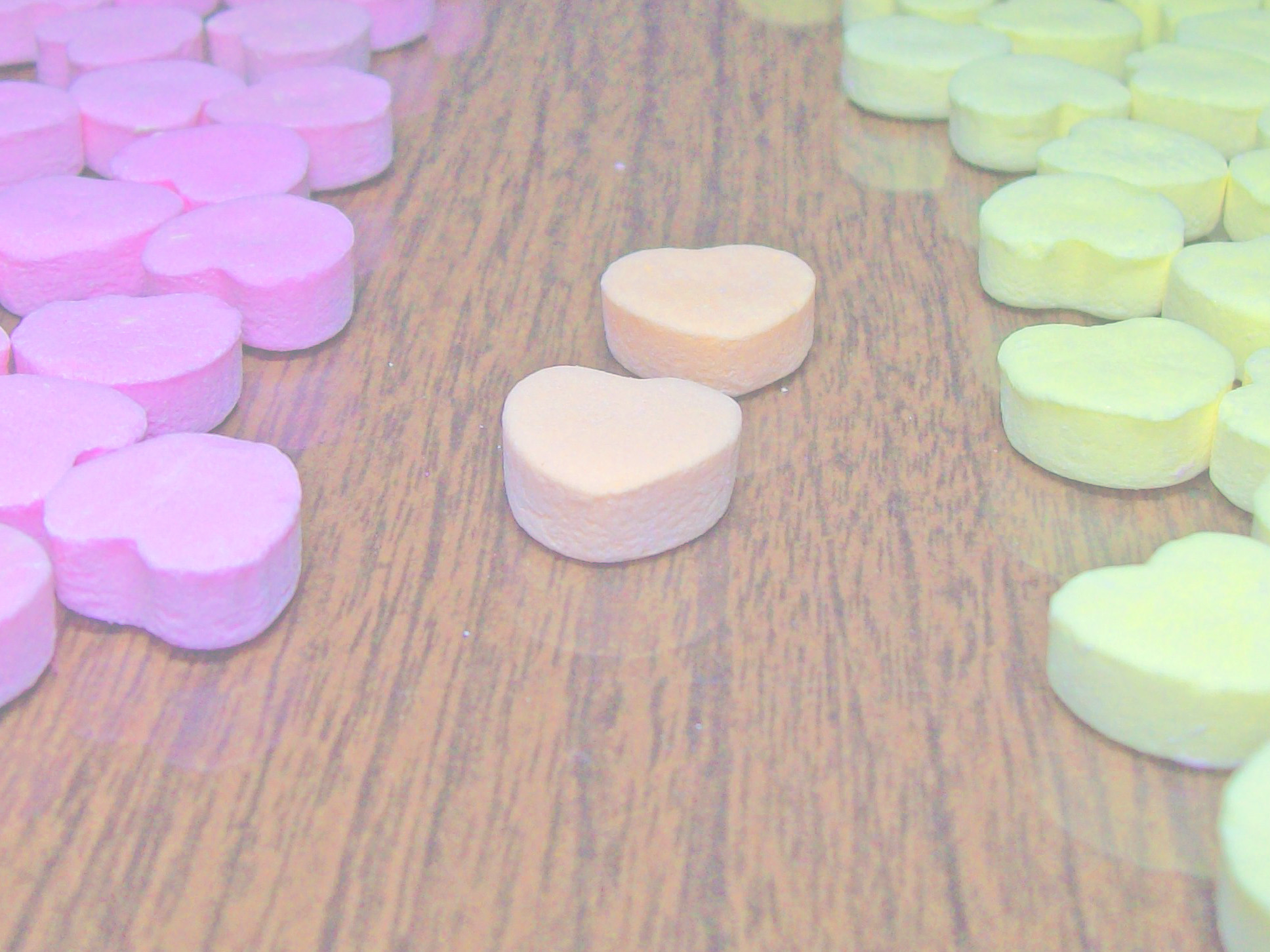 A faded image of candy hearts.; Is It Legitimate to be in the Middle? One Reason People Dismiss Intermediate Identities