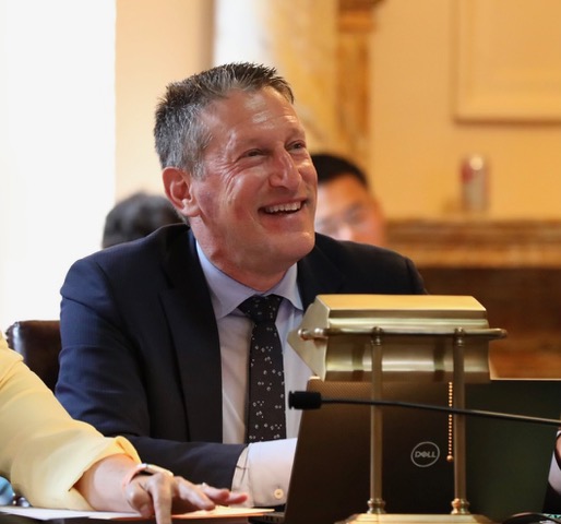 Andrew Zwicker, a man with short hair in a suit smiling.; The Physics of Politics