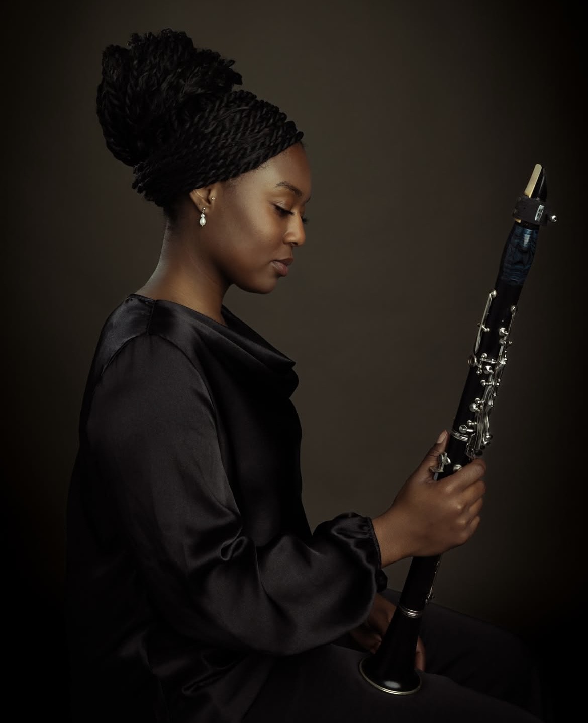 A woman holding an clarinet and looking down at it.; Degree Recital:&nbsp;Jalen Mims, clarinet, with Neilson Chen, piano