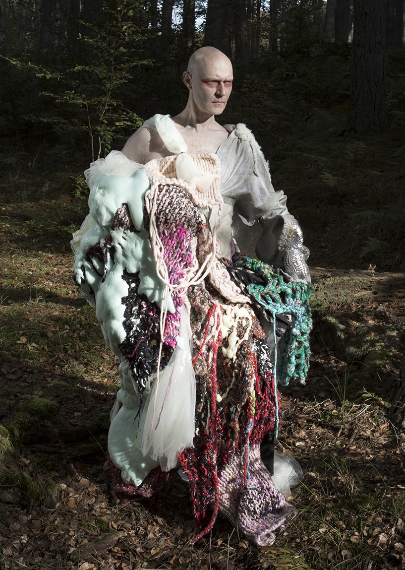 A person wearing a dress made of discarded materials like nets and shells.; Visit https://https://www.sionparkinson.com/