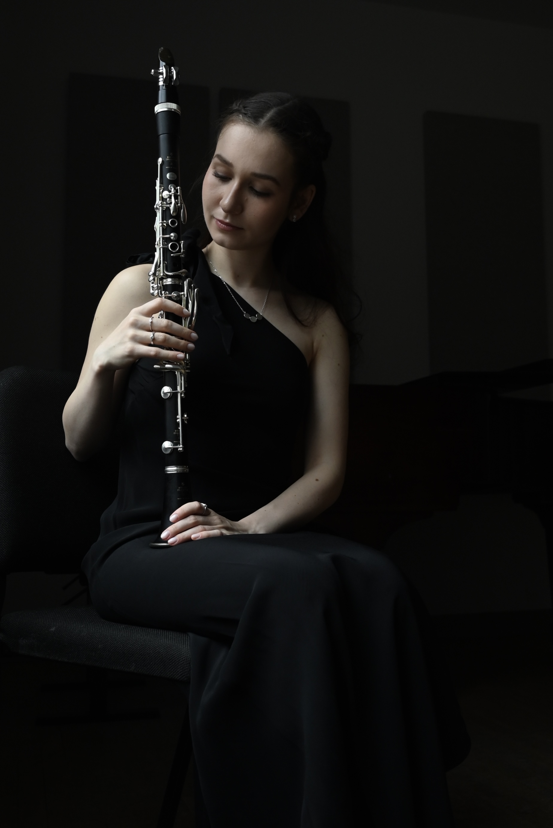 A wind instrumentalist holding her instrument on her lap.; Degree Recital:&nbsp;Eszter Pokai,&nbsp;clarinet