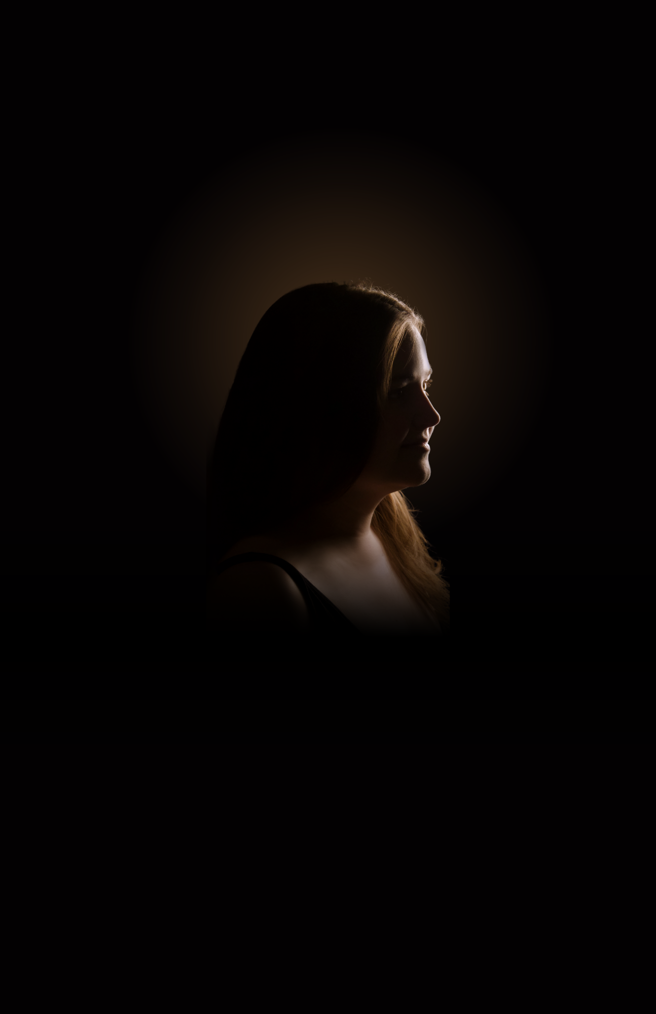 A person in shadow looking to the side.; Degree Recital:&nbsp;Megan Maloney, soprano, with&nbsp;Gabrielė Žemaitytė, piano