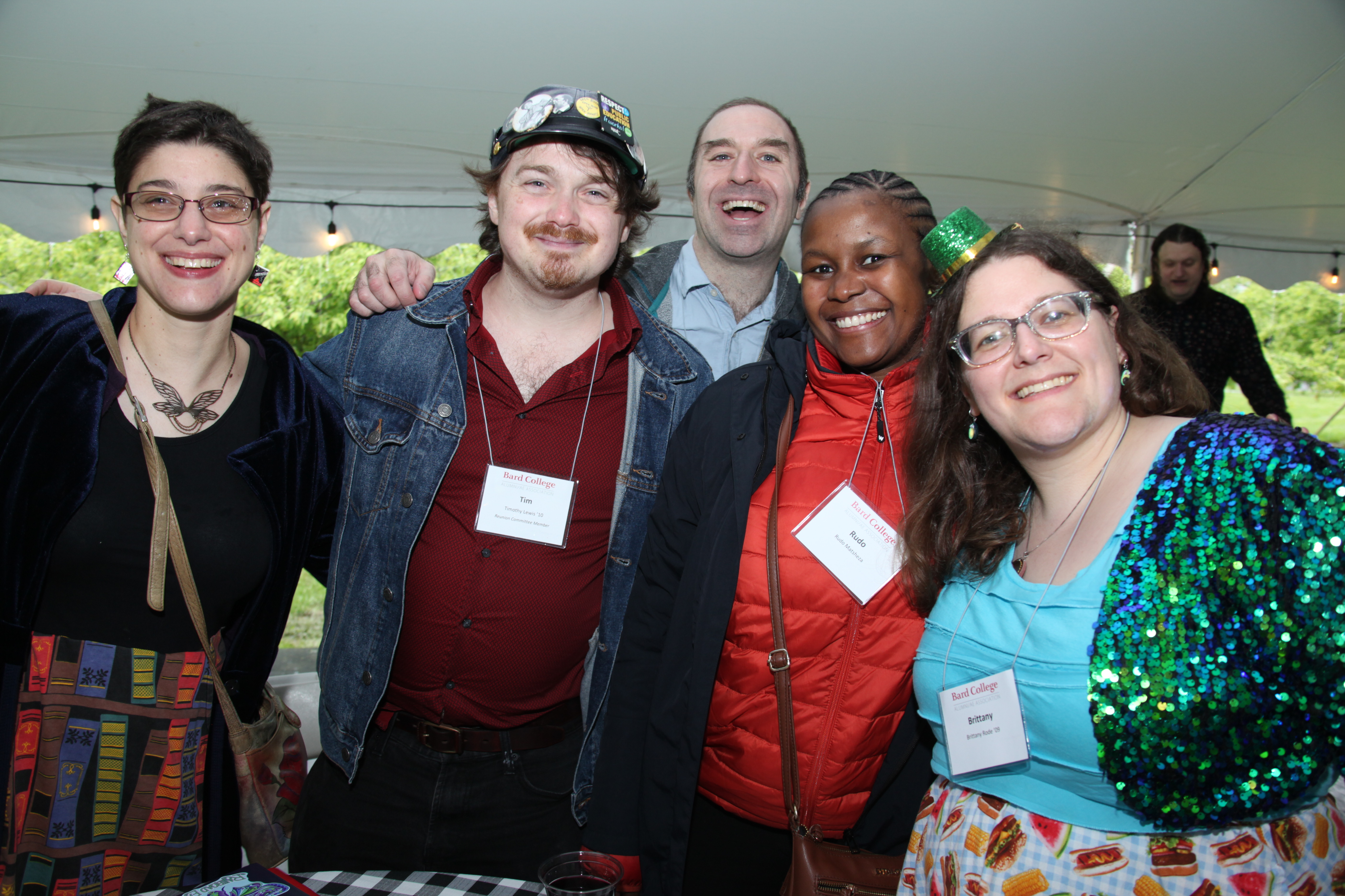 Five alumni with name tags smiling for the camera.; Visit https://alums.bard.edu/alumni-weekend/