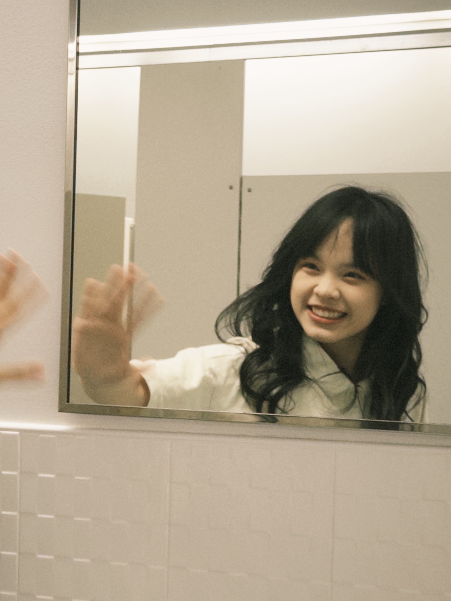 Ivy Chen waiving in a mirror.; Third Year Recital