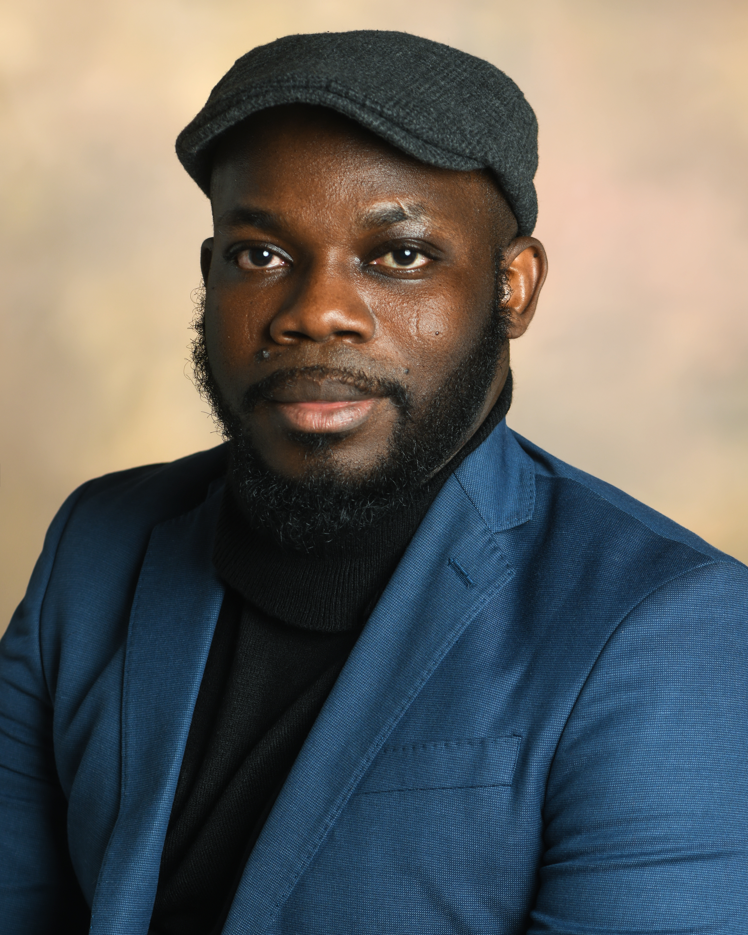 DM Aderibigbe in a hat and blue suit.; A Reading with DM&nbsp;Aderibigbe