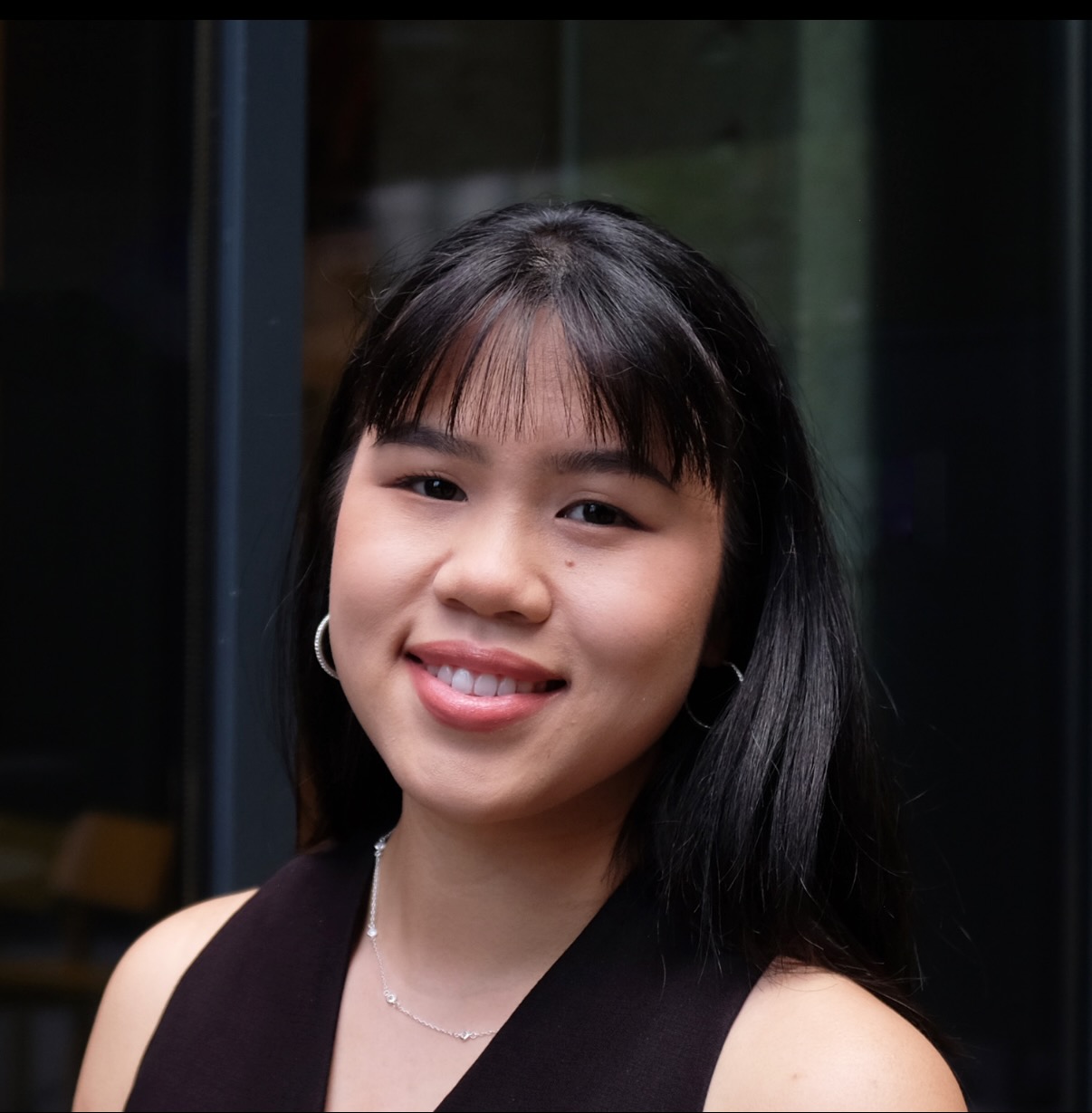 Jing-Yi Sutherland smiling against a neutral black background.; Undergraudate Degree Recital: Jing-Yi Sutherland, cello