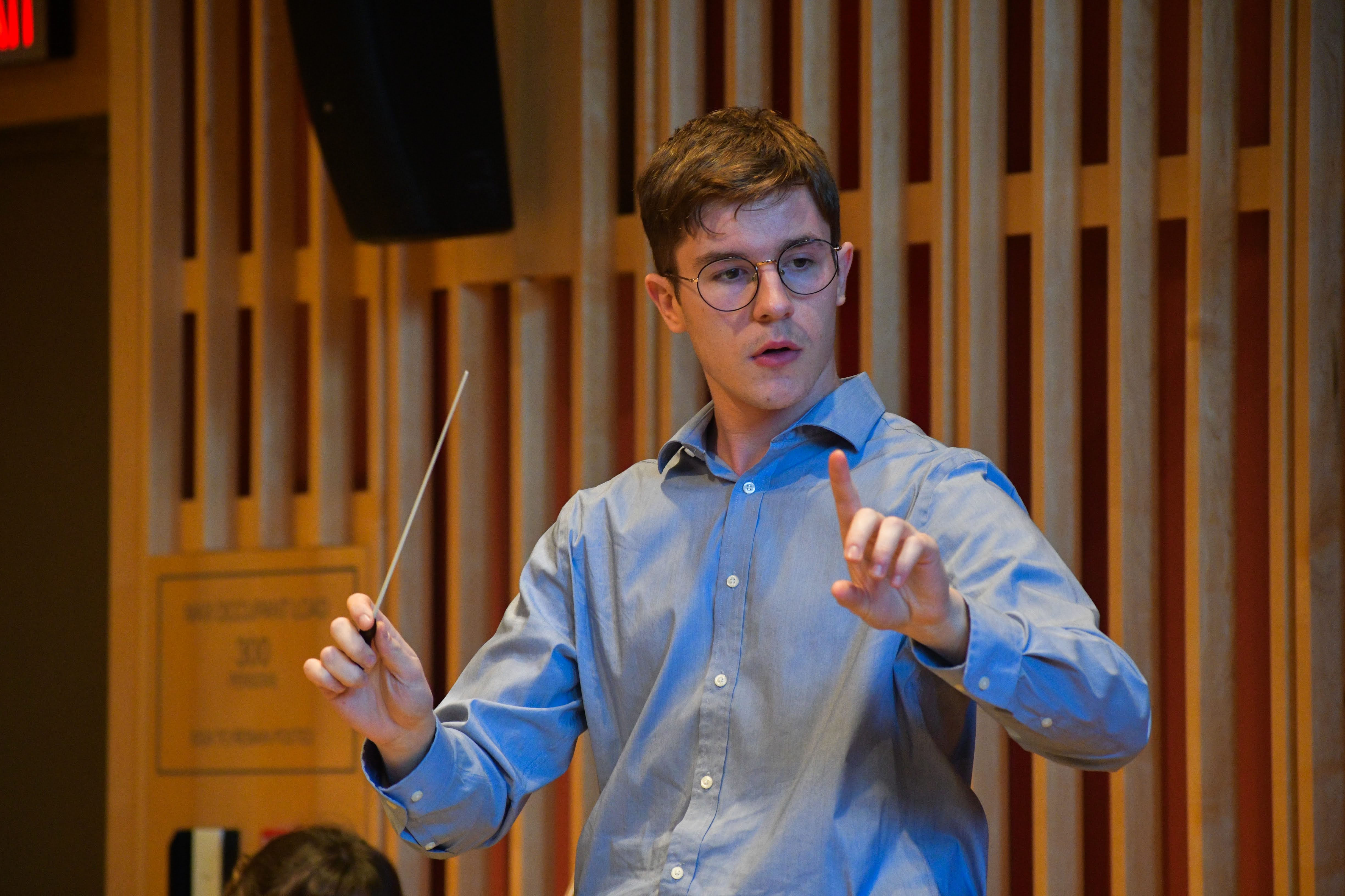 A close up of a student conductor performing.