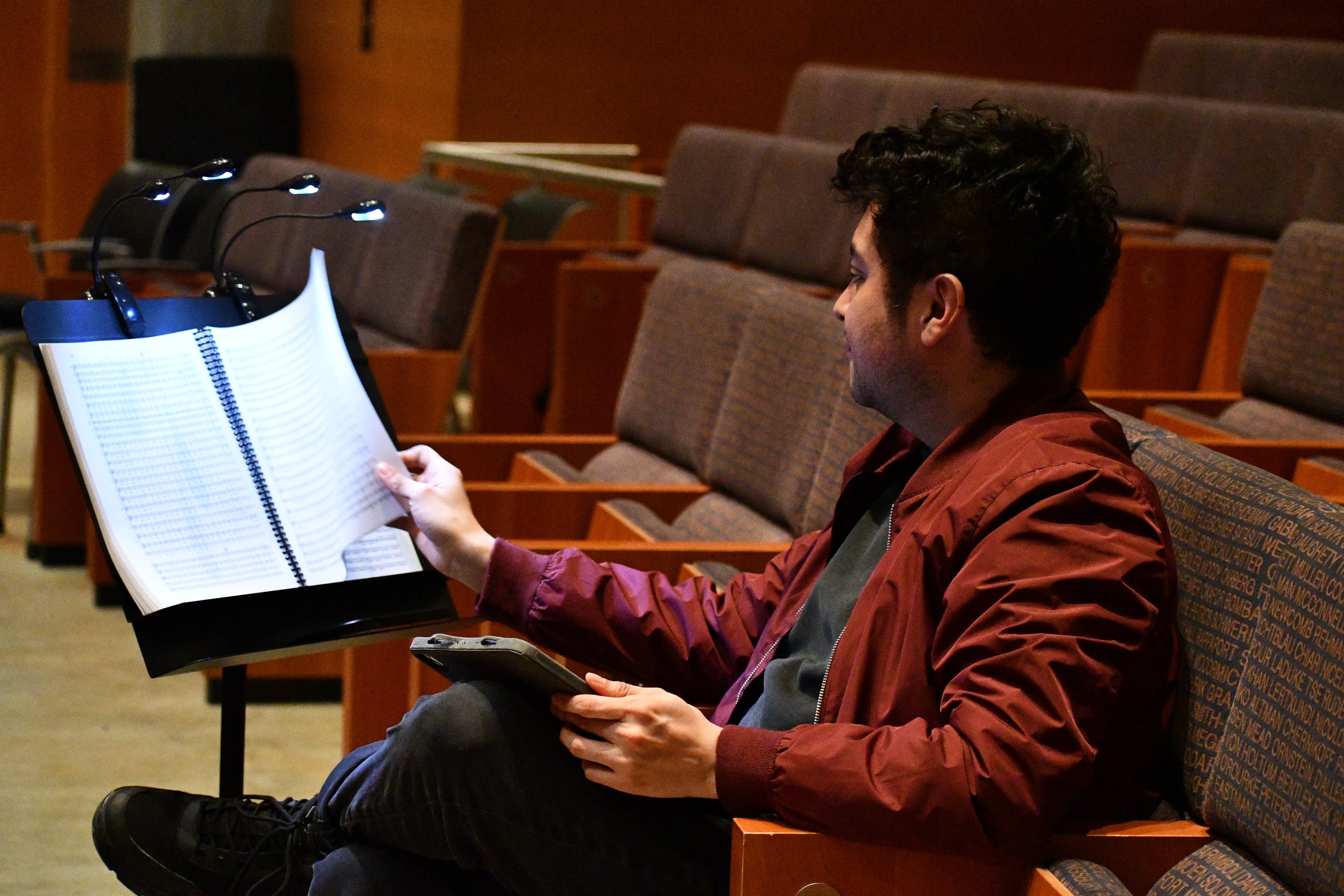 A student turning the page on a music booklet.