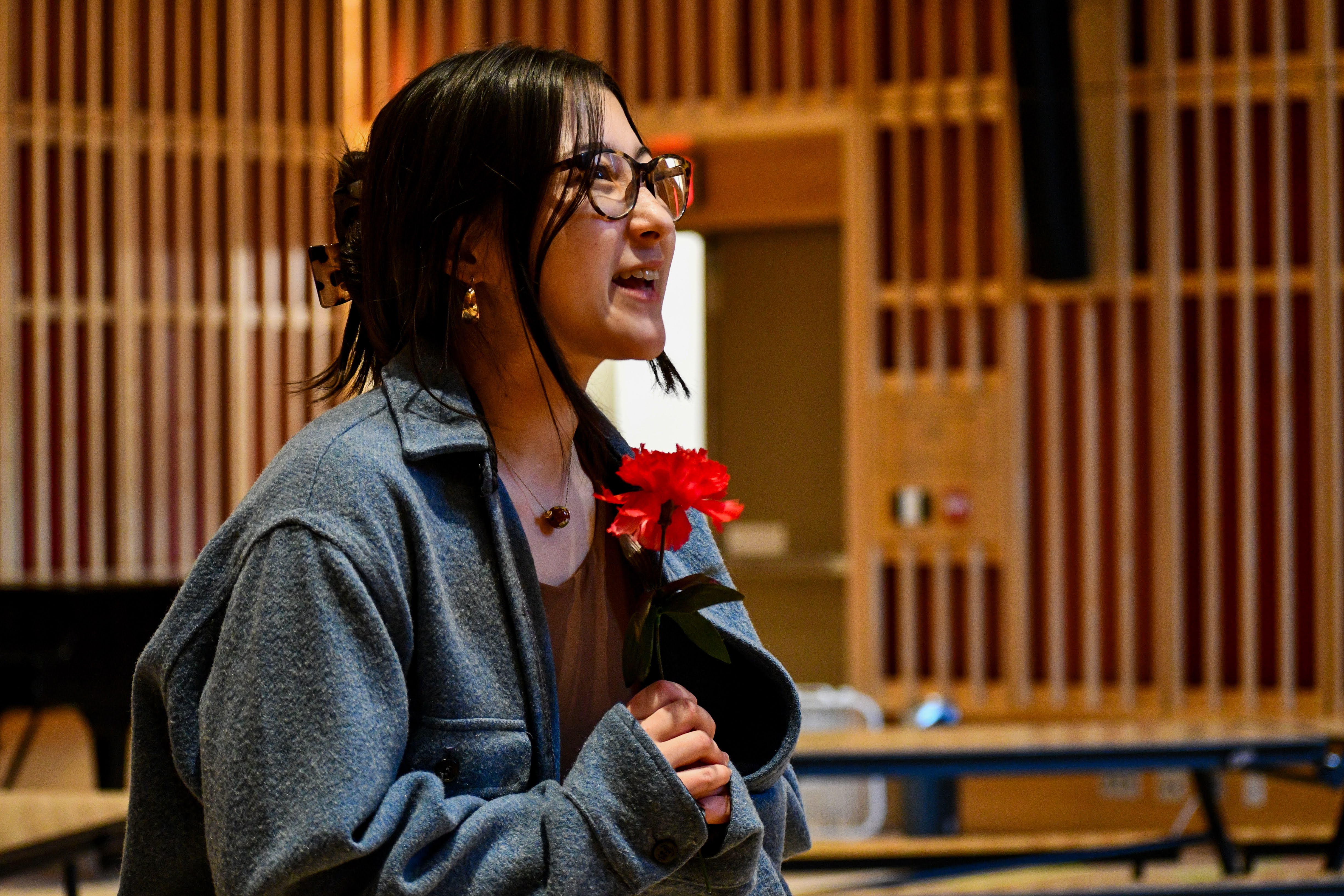 A woman sings with clasped hands.