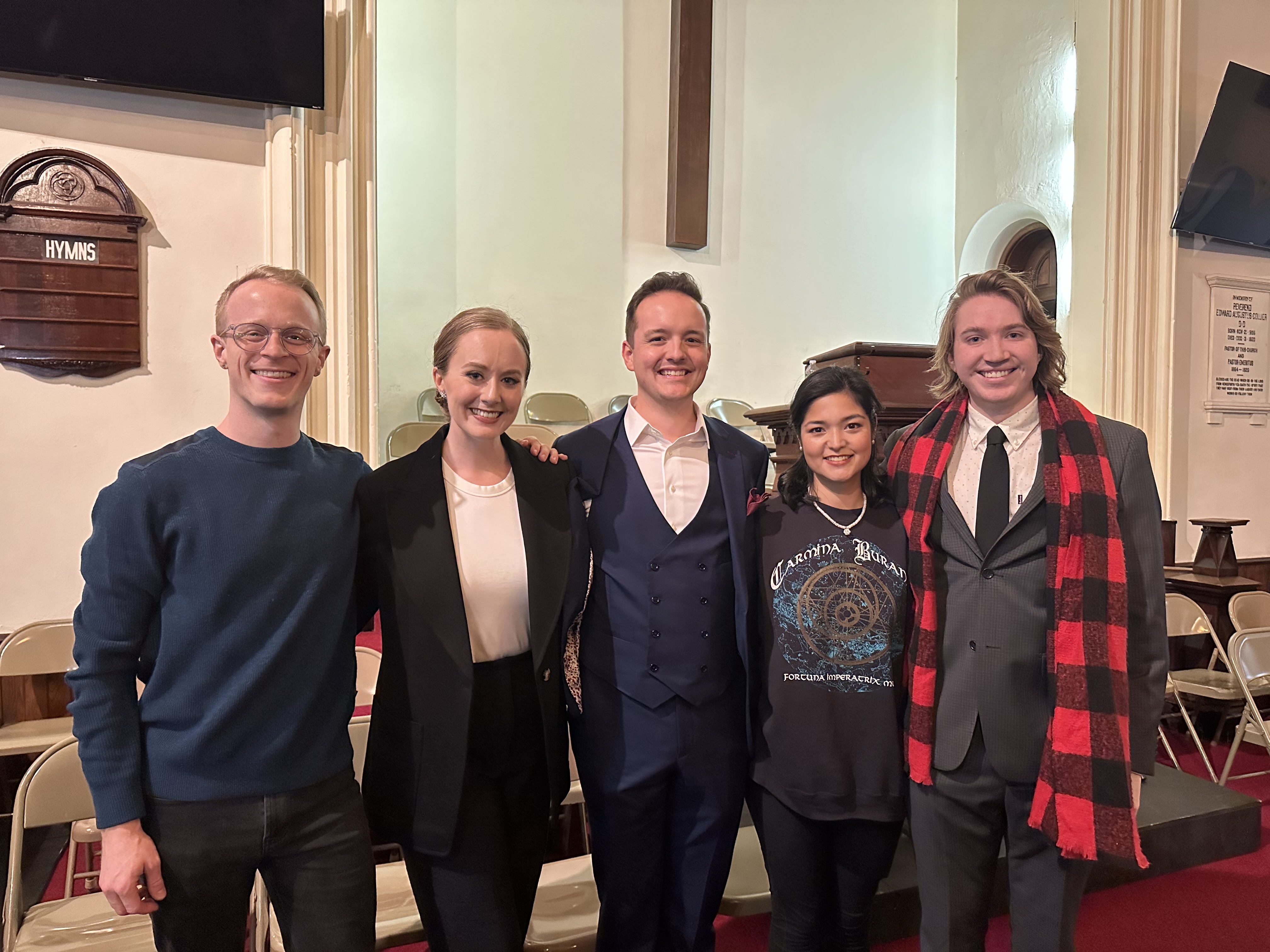 A group of people pose for a photo, smiling.